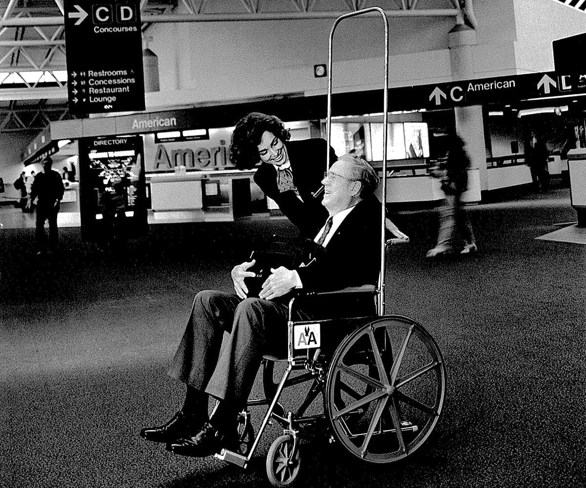Airport worker assisting man in wheelchair